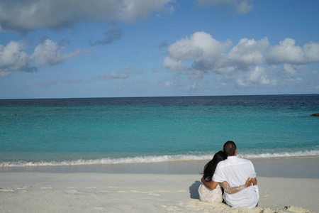 情侣坐拥在海边沙滩后景
