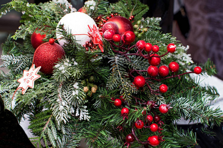 冷杉树枝上有圣诞装饰品。 红色圣诞球星星和浆果
