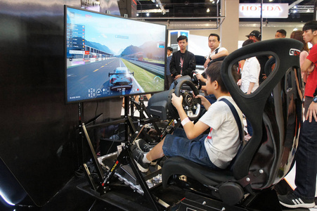马来西亚吉隆坡2017年11月23日人们玩赛车模拟游戏。 显示与大屏幕显示器完成驾驶舱控制，就像一辆真正的赛车。