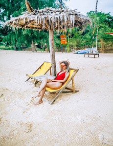 泰国Koh Phangan海滩椅上放松的美丽年轻女子