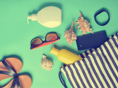 海滩袋和配件，放松在海滩布局的蓝色粉彩背景。 海上避暑胜地的概念。 俯视图平视图最小