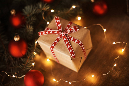 圣诞树上有礼品盒，装饰花环和木制背景装饰