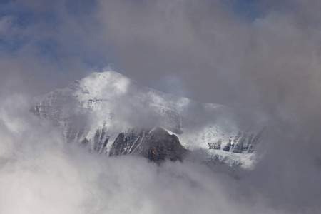 高山景观被雪和云覆盖。