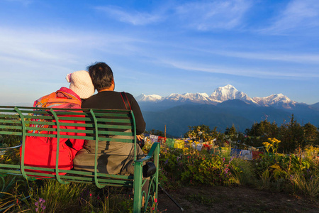 游客坐在长凳上看坡山。