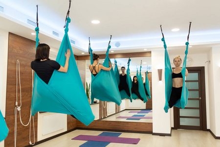 女人在吊床上做飞行瑜伽伸展运动。 健康和健康的生活方式。
