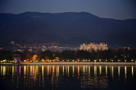 在黄昏时分，建筑物的灯光反射在gelendzhik海湾