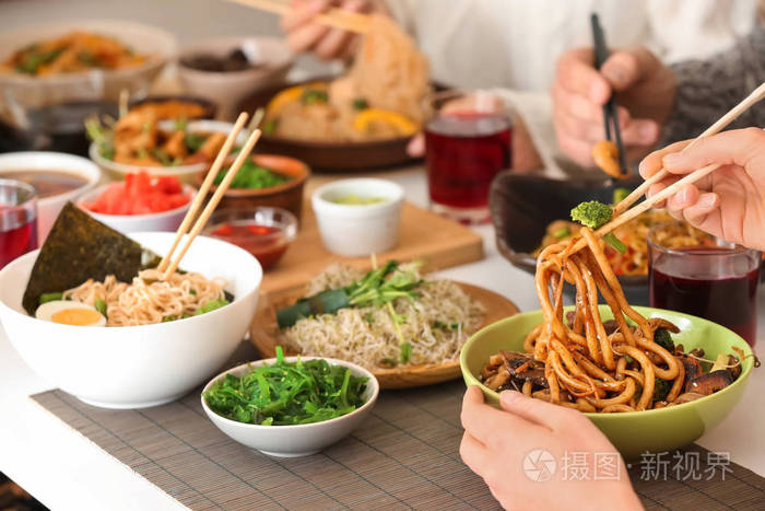 女人和朋友在餐桌上吃美味的中餐