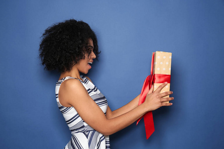 非裔美国年轻女子的肖像，彩色背景上有礼品盒