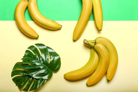 成熟甜香蕉和热带叶子的颜色背景