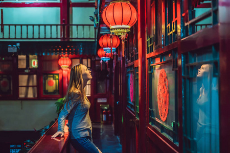 年轻的女游客看着中国传统的灯笼。中国新年。中国旅游理念