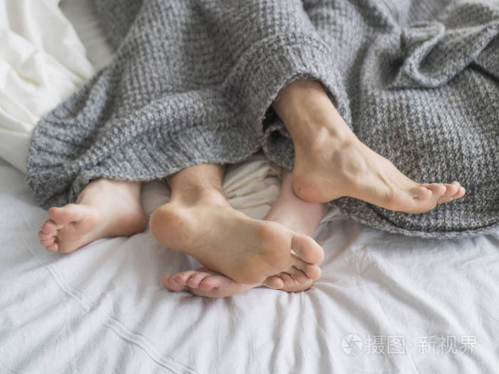 照片 夫妇睡在床上.近距离看一对夫妇的脚.爱情和人际关系概念.jpg