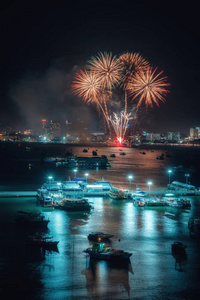 烟花国际五颜六色的芭堤雅海滩城市景观在夜景广告旅游活动假期。 帕塔亚市