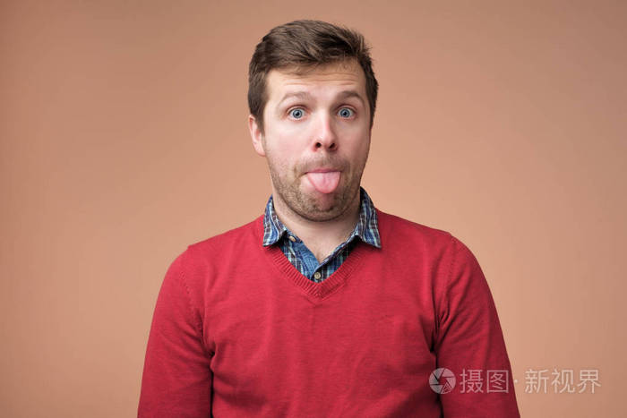 年轻英俊的男人伸出舌头出来高兴与有趣的表情