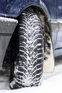 冬天正在下雪。 汽车车轮冬季轮胎。 快关门。 有调色剂。
