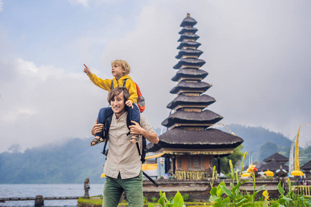 爸爸和儿子的背景 pura 乌伦达努布拉坦, 巴厘岛。巴厘岛布拉坦湖上被鲜花环绕的印度教寺庙。主要的湿利水上寺庙在巴厘岛, 印度