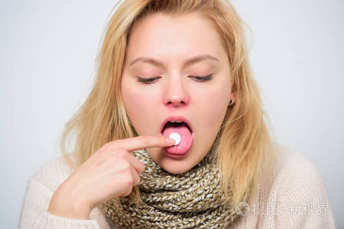 家庭治疗理念。女孩吃药来退烧。感冒和喉咙痛