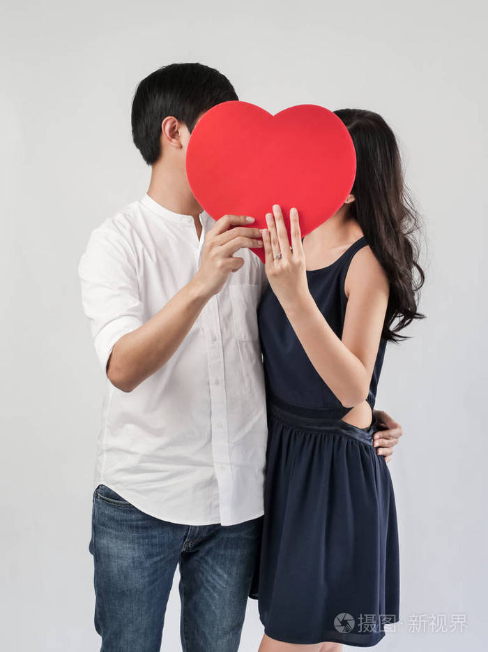 幸福的夫妻相爱,抱着红色的心形情人节概念.照片-正版