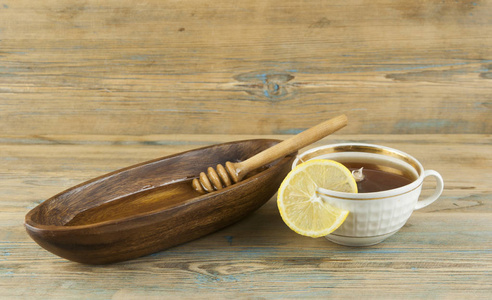 木制背景上的柠檬和蜂蜜茶