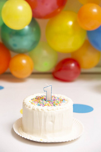 s first birthday with wall of colorful balloons on background, s