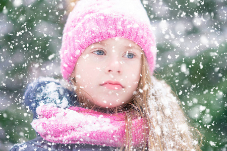 一个蓝眼睛的金发女孩正沉思地看着下雪。