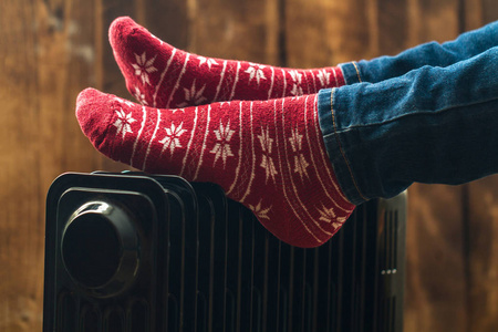 s feet in Christmas, warm, winter socks on the heater. Keep warm