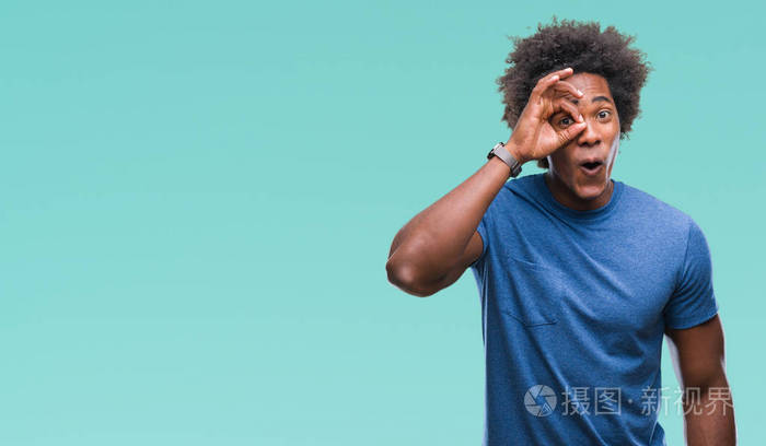 美国黑人男子在孤立的背景下做ok手势,震惊与惊讶的脸,眼睛通过手指.