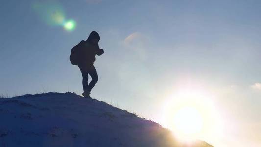 带着背包的游客在雪山上旅行。登山者从雪山轻轻落下, 在灿烂的阳光下滑落