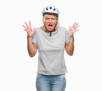 中年白种人骑自行车的女人戴着安全帽，在孤立的背景下庆祝疯狂和疯狂的成功，举起手臂和闭上眼睛尖叫兴奋。 赢家概念