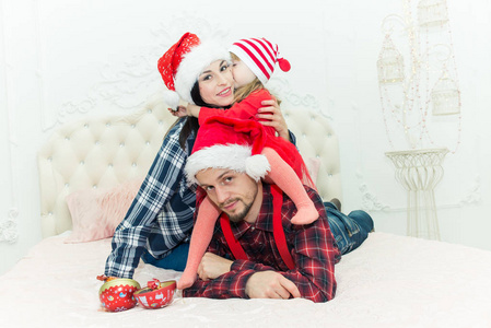 s father and little girl dressed in holiday wear red hats, jeans