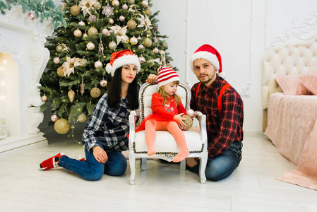 s father dressed in festive clothing red hats, jeans and clashed