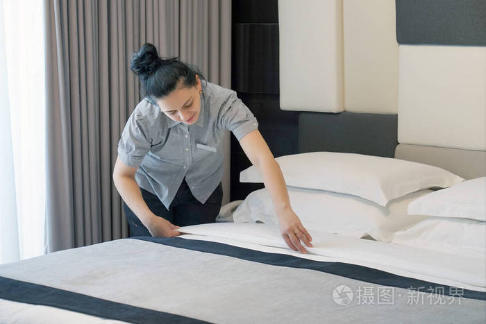酒店房间里的女佣整理床铺 客房服务员