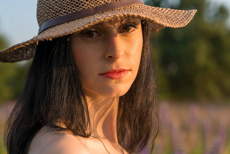 s crimson wicker hat at sunset in the field of lupine