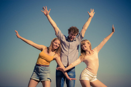 友谊幸福暑假概念..一群朋友，男孩，两个女孩在户外玩，伸展手臂庆祝