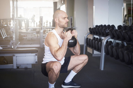 射击的人在健身房做哑铃运动，以创造更多的肌肉身体。