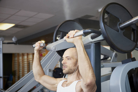 近距离的人在健身房做哑铃运动，以创造更多的肌肉身体。
