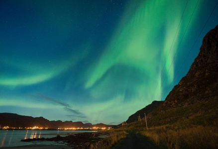在挪威洛福顿群岛, 在沙滩上的极光, 克瓦尔维卡和斯卡格桑登与石头。挪威洛福敦群岛的北极光。星空与极光。夜风景与绿色