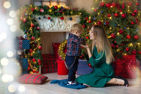 s holidays. Toddler with mom in the festively decorated room wit