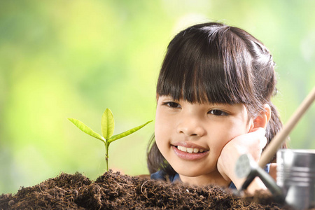 一个女孩在土壤上种植幼株，希望有良好的环境
