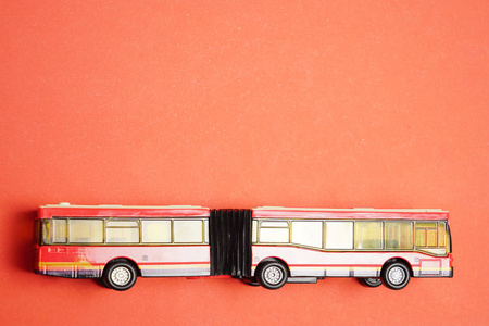 红色背景上长红色巴士模型玩具。 铭文的空拷贝空间。