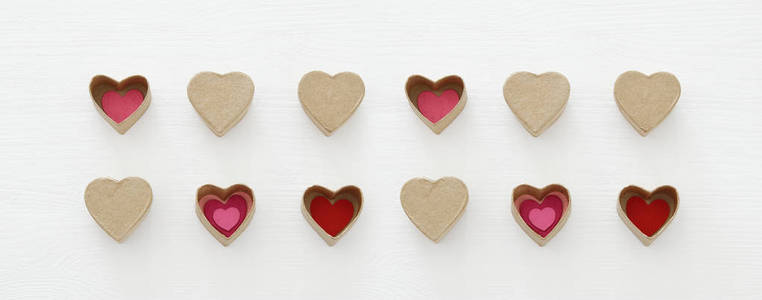 s day concept. hearts as paper gift boxes over wooden white back