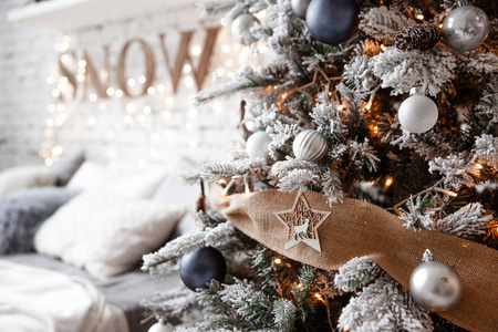 宽敞的白光卧室，带有阁楼风格，有一棵装饰的圣诞树和一个花环。