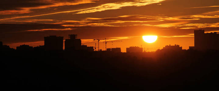 全景城市景观与城市天际线的轮廓对夕阳。 白俄罗斯