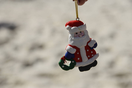 圣诞老人娃娃，海滩背景模糊。