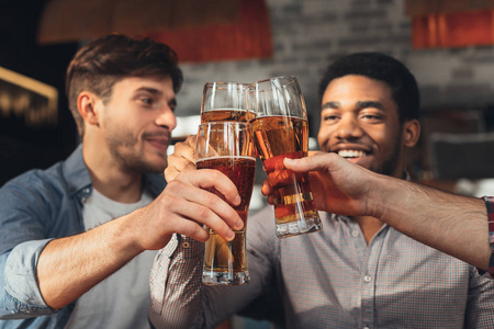 在酒吧喝啤酒喝眼镜的男性朋友