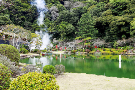 池塘和花园有绿色的水和树的倒影，位于乌米吉戈库或海洋地狱，有一个蓝色的热水池塘，日本北田