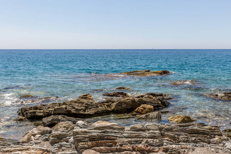 西班牙一片清澈的海水海滩岸边的巨大岩石