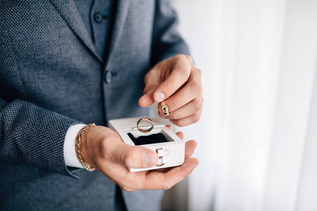 s hand holding engagement rings in box ,close up