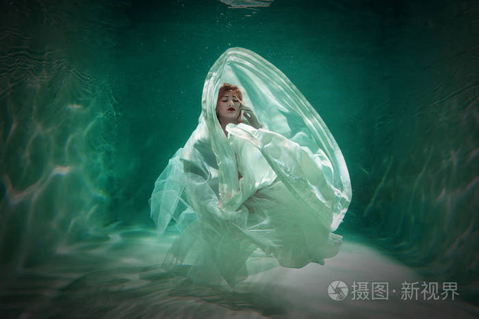 性感苗条的白种人女人独自穿着漂亮的衣服在水里摆姿势