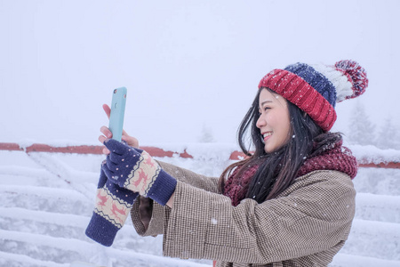 自拍女士与红色羊毛帽，感觉非常高兴和寒冷的雪天气下，在新热中观察甲板日本阿尔卑斯山。