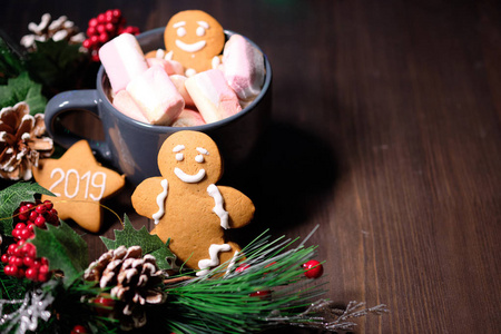 姜饼干和棉花糖棕色背景与圣诞树, 蜡烛和圣诞灯。复制空间